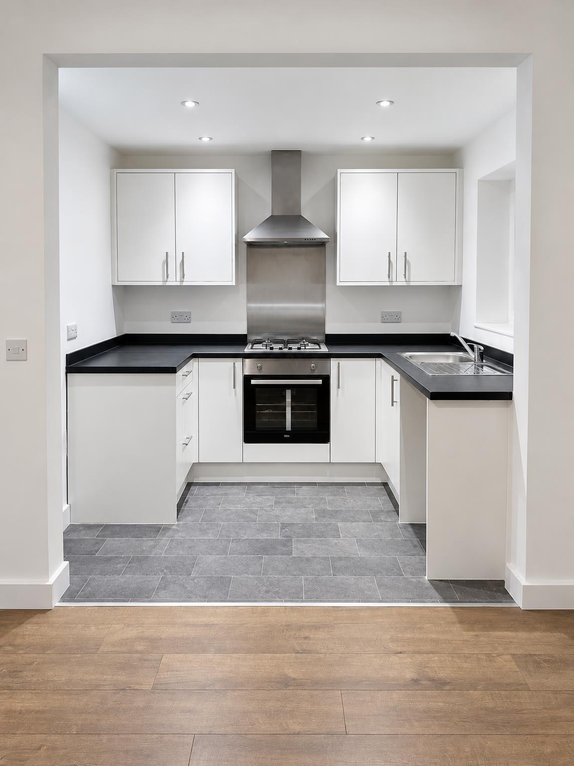 New white U-shaped kitchen with integrated oven